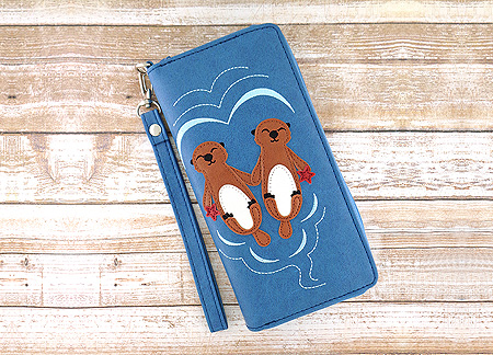 LAVISHY Adora collection wholesale hand-holding sea otter lovers applique vegan large wristlet wallets to gift shop, clothing & fashion accessories boutique, book store in Canada, USA & worldwide since 2001.